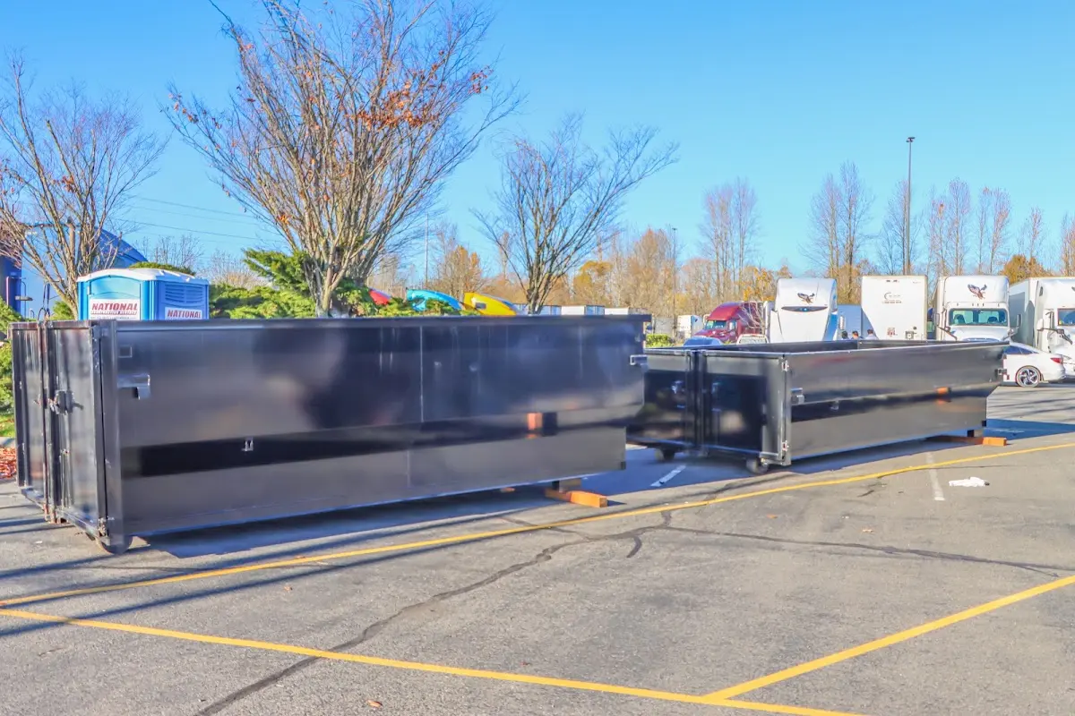 Professional dumpster rental service with roll-off container on residential driveway in Bastrop